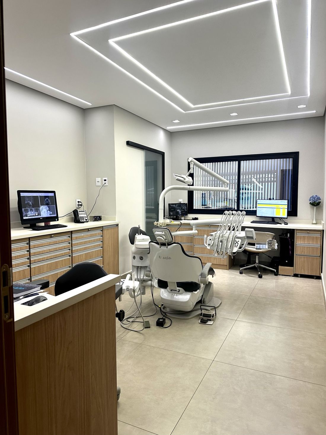 Consultório equipado com cadeira odontológica e monitores para planejamento digital