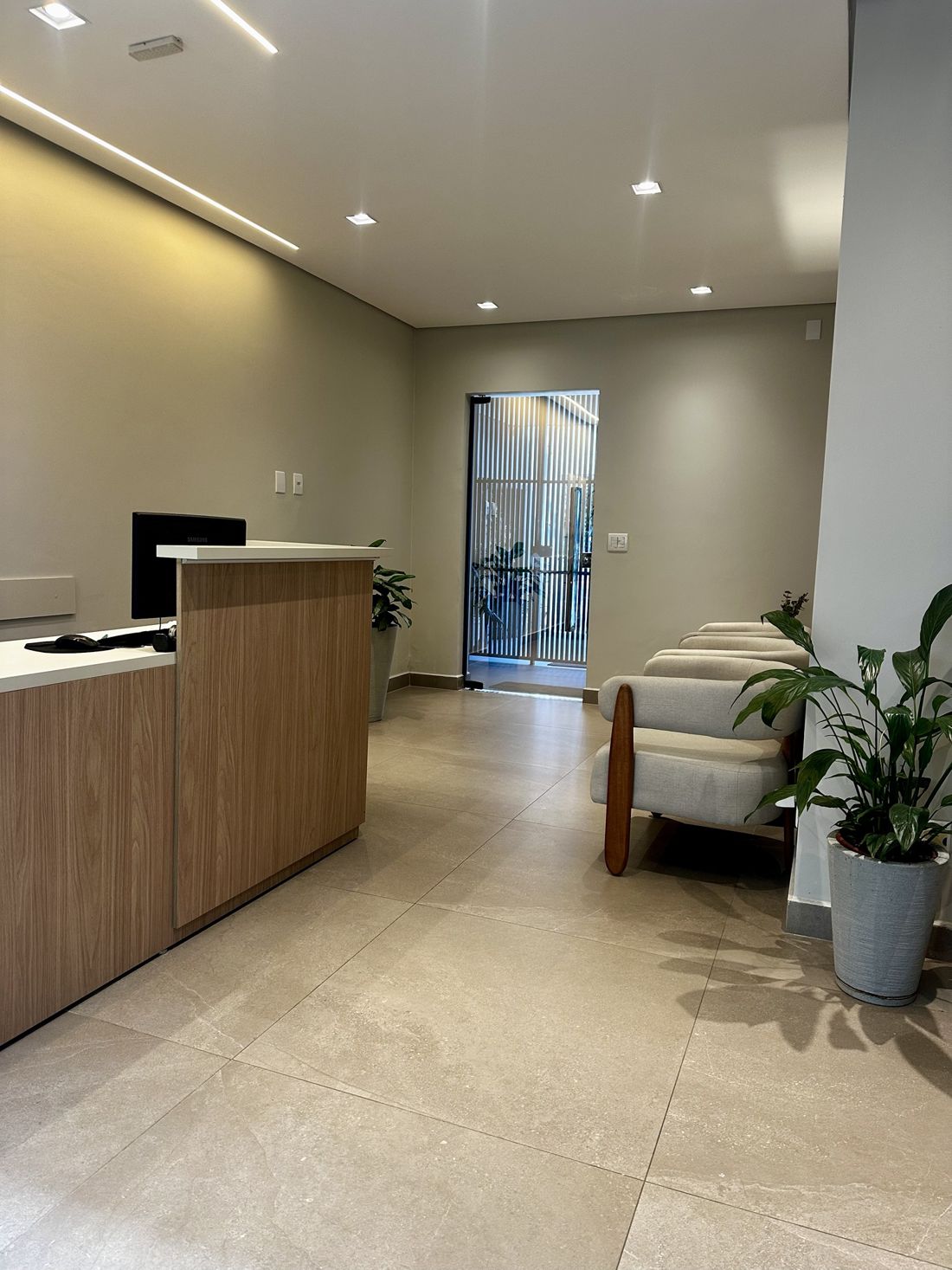 Recepção da Russo Odontologia, com balcão em madeira e poltronas