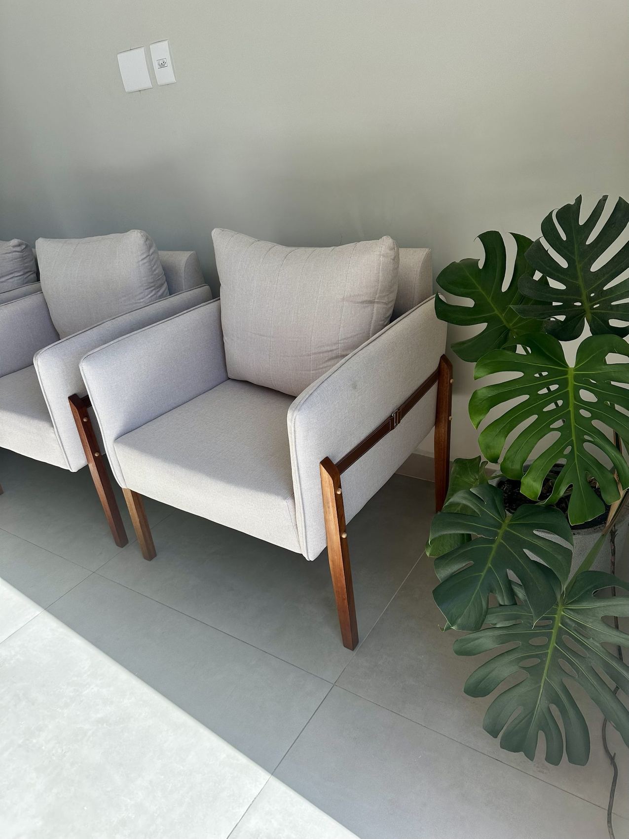 Sala de espera com poltronas e planta